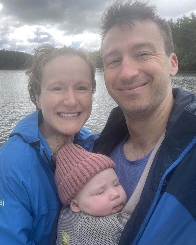 Luke and his family on a dock at the edge of a lake.
